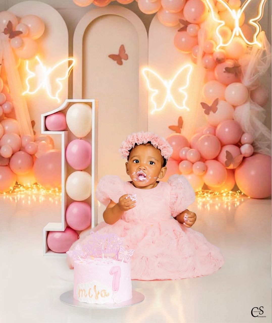 Baby girl enjoying cake at a pink butterfly set