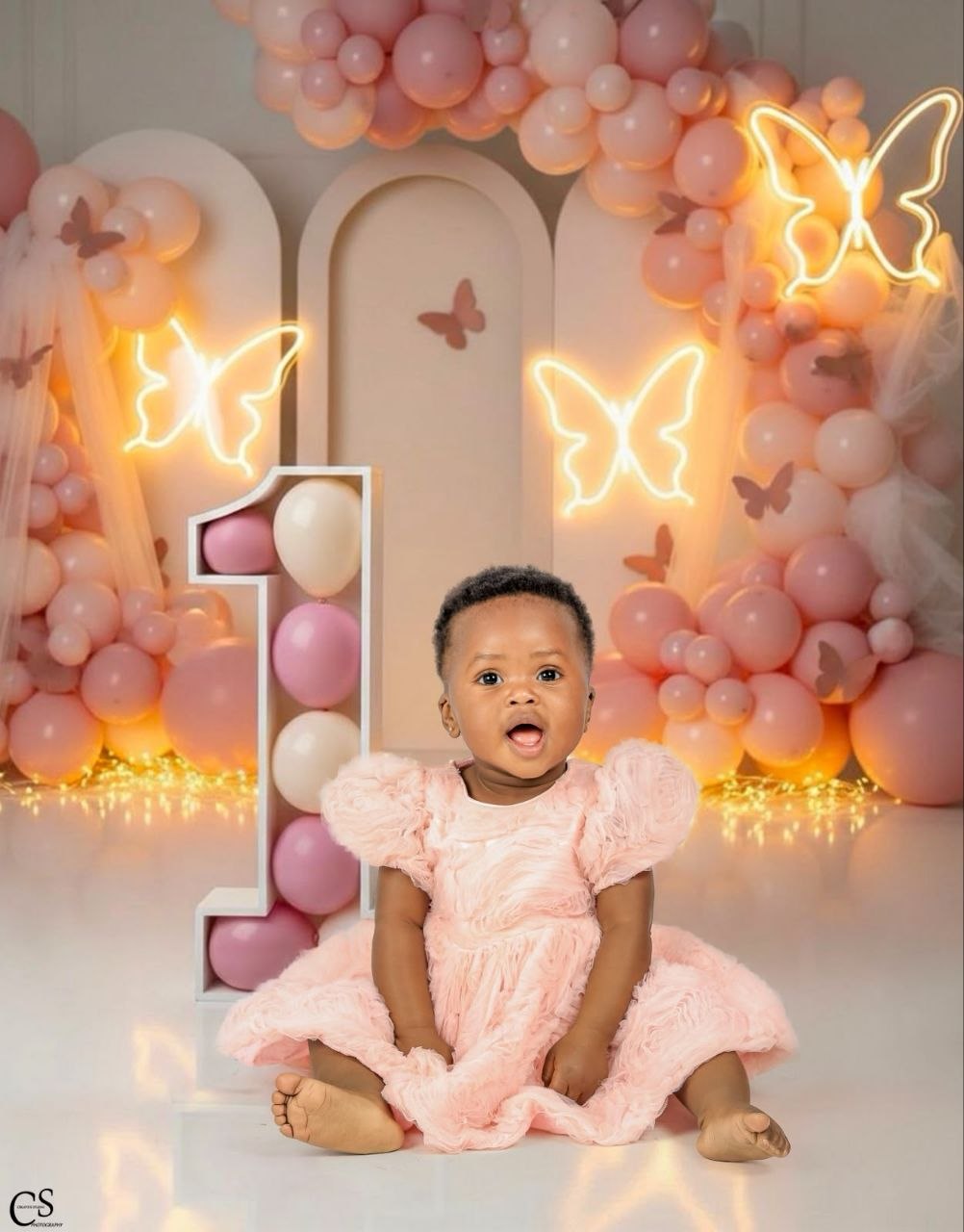 Baby girl in a pink dress at her first birthday set